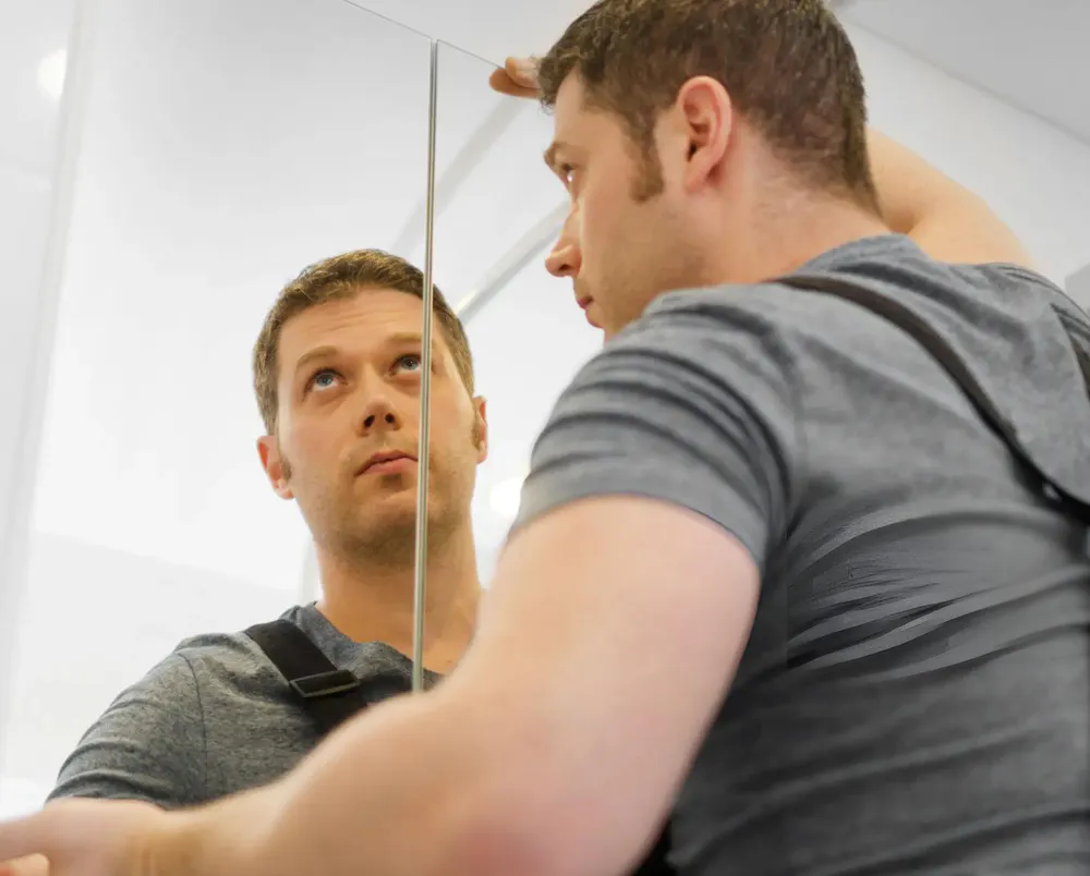 A man is installing a mirror