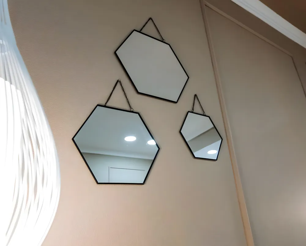 Three identical hanging mirrors