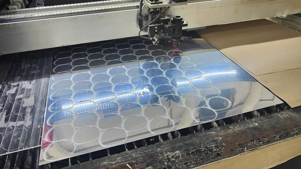 A plastic mirror undergoing laser cutting
