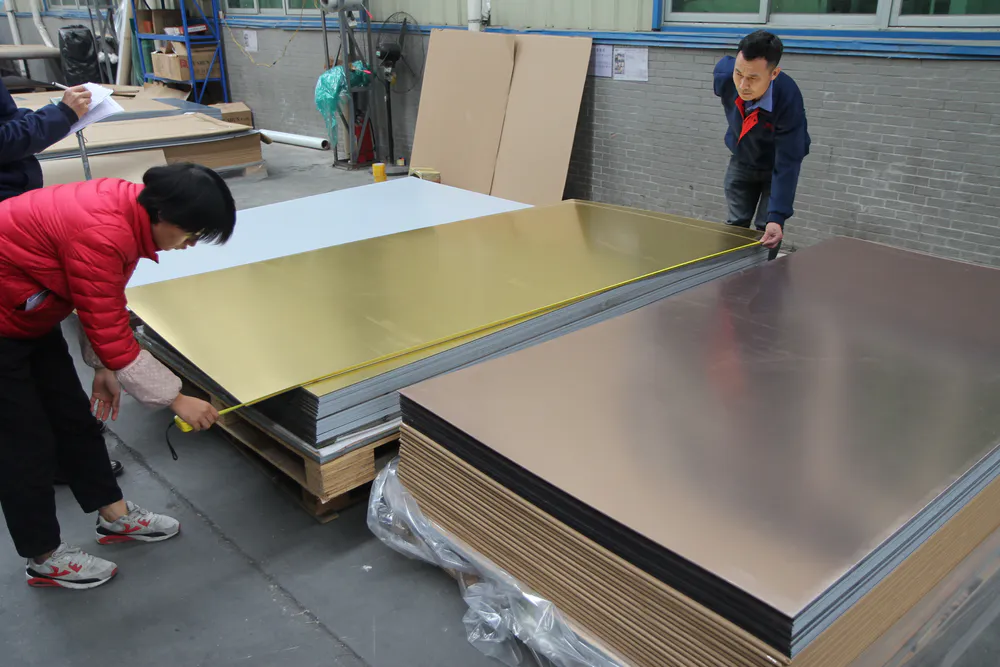 Employees are measuring the dimensions of the acrylic mirror sheets awaiting shipment