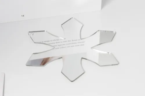 A snowflake-shaped plastic mirror cut by laser